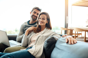 Canvas Print - Great company is always rare to find. Portrait of an affectionate young couple using a laptop while relaxing on their sofa at home.