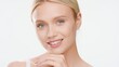 © pavel_dp - Big close-up beauty portrait of young white-skinned woman who touches her chin and smiles wide for camera on white background | Moisturizer commercial concept