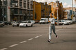 © Yaroslav Astakhov - Full length shot of female jogger in sportswear and headphones training in the city. Wellness
