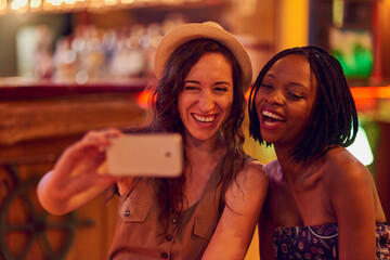 Sticker - Fun times with my favourite person ever. Cropped shot of two young friends taking a selfie in a bar.