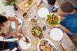 © Chanelle Malambo/peopleimages.com - Serving love and happiness with every meal. High angle shot of a young family of four enjoying a meal together around a table outdoors.