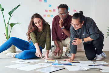 Poster - Planning adequately is the first step to achieving success. Full length shot of a group of young businesspeople going over paperwork and ideas at work.