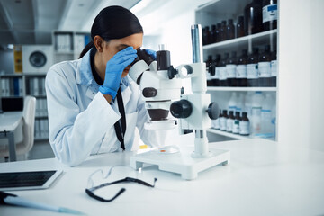 Wall Mural - ill find you and ill fix you. shot of a young scientist using a microscope in a laboratory.