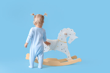 Sticker - Adorable baby girl with rocking horse on blue background