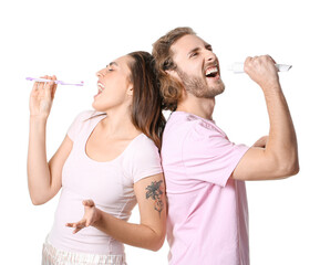 Canvas Print - Young couple with toothbrushes and paste singing on white background