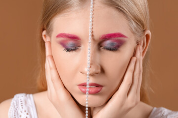 Poster - Woman with creative eyebrows and makeup touching face on color background