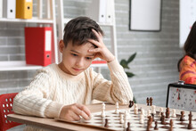Little Boy Playing Chess During Tournament In Club
