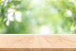 Empty wooden table with garden bokeh for a catering or food background with a country outdoor theme,Template mock up for display of product