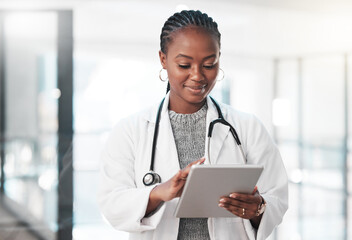 Who has time to be tied down to a desk. Shot of a young doctor using a digital tablet in a modern hospital.