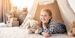© Ievgen Skrypko - Little girl lying in wigwam with plush teddies in light room