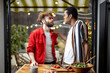 © rh2010 - Two brightly dressed stylish guys having fun while making salad together indoors on background of backyard. Concept of gay couples. Caucasian and hispanic man having close conversation