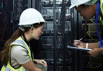 Sticker - Lets make a note and come back to it. Cropped shot of two attractive female programmers working in a server room.