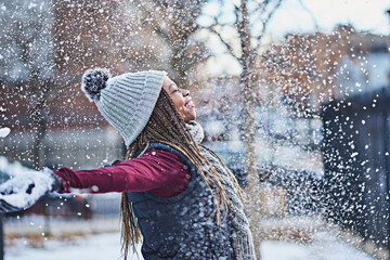Aufkleber - Snowflakes, like kisses from the sky. Shot of a happy young woman throwing snow on a wintery day outdoors.