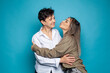 © artmim - Beautiful family of mother and daughter together, hugging and kissing on blue studio background