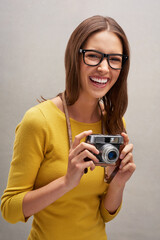 Sticker - Ive got some great shots. Studio portrait of an attractive young female photographer posing with her camera against a grey background.