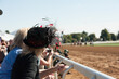 © toninewphotography - Woman watching horse race at race track with big fancy hat