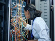 © Siphosethu Fanti/peopleimages.com - She knows exactly where each cable should be. Cropped shot of an attractive young female programmer working in a server room.