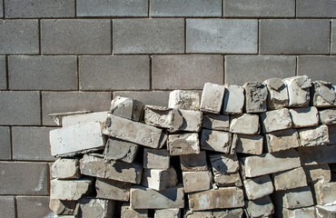 Dismantled wall of a building made of old sand-lime brick against the background of a new wall