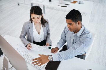 Wall Mural - the companys top performance boosters. shot of a young businessman and businesswoman using a compute