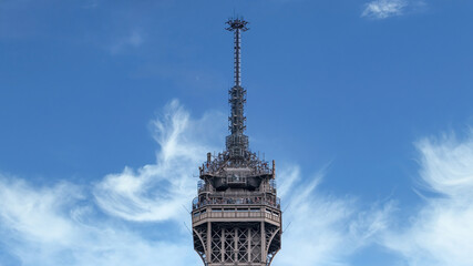 Paris, France - September 2016: Mobile telecommunications antennas and equipment at top of Eiffel tower with clear blue sky