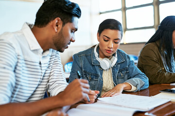 Wall Mural - Doing it for our future. Cropped shot of two young university students working together in class.