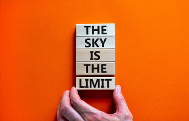 Sky is limit symbol. Concept words The sky is the limit on wooden blocks. Businessman hand. Beautiful orange table orange background. Business motivational stress spice of life concept. Copy space.