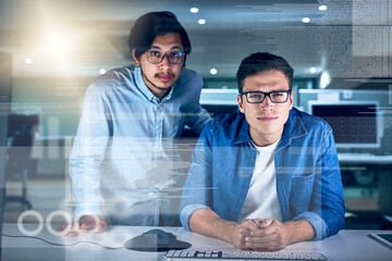 Leinwandbilder - They are the specialists in this field of work. Portrait of two young male programmers working on a computer together in the office at night.