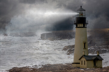 a tall whit lighthouse shinning light at night in a storm with a rough ocean and fog