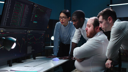 Team of traders working at monitor computer and browsing online in trading office 