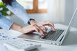 © Daenin - Close-up shot of a young woman typing on a keyboard.