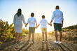 Families stand together forever, no matter what. Rearview shot of a family bonding together outdoors.