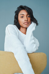 Poster - Learn to put yourself first. Shot of a beautiful young woman sitting on a chair against a teal background.