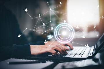 Hand using laptop and Bullseye is a target of business with a notification people icon, Social Distancing ,Working From Home concept,international consulting company. Social networking hologram icons.