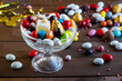 Colorful Turkish almond candies in a glass bowl on wooden table with chocolates.The Sugar Feast after Ramadan.
