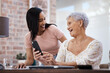 © Nicholas Felix/peopleimages.com - The smart way to invest those savings. Shot of a young woman using a smartphone with her elderly mother while going through finances at home.