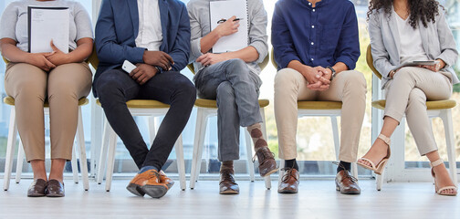 Wall Mural - please wait your turn. closeup shot of a group of businesspeople sitting in line in an office.
