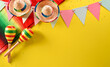 Cinco de Mayo holiday background made from maracas, mexican blanket stripes or poncho serape and hat on yellow background.