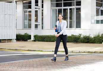 Sticker - Taking strides toward my destiny. Shot of a young businesswoman enjoying a cup of coffee while making her way work.