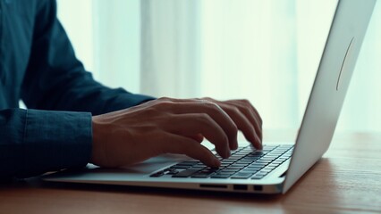 Wall Mural - businessman hand work on capable laptop computer at office table close up shot and selective focus a