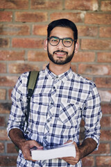 Fototapete - I value my education. Cropped shot of a handsome young male university student standing outside against a facebrick wall.