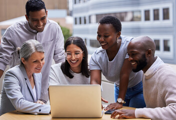 Have a burning desire to succeed. Shot of a group of professional coworkers using a laptop together at work.