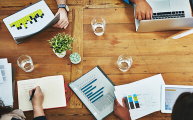 Aufkleber - Lets brainstorm. High angle shot of designers working around a table in the office.