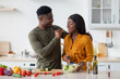 © Prostock-studio - Romantic Black Spouses Having Fun While Preparing Food In Cozy Kitchen