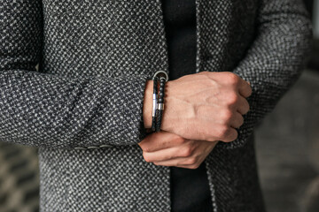 Wall Mural - Businessman holds hands together. Man in a gray coat jacket. Stylish men's accessories up close.