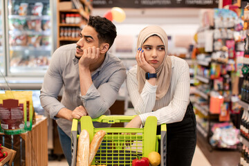 Wall Mural - Middle Eastern Spouses Standing With Cart Shopping Groceries In Supermarket