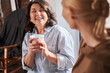 © Yakobchuk Olena - Woman laughing with her young teacher and listening her while drinking coffee