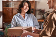 © Yakobchuk Olena - Mature woman holding cupboard box with handmade dishes and having conversation with teacher