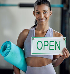 Poster - Come train with me. Portrait of a sporty young woman holding an exercise mat and open sign in a gym.