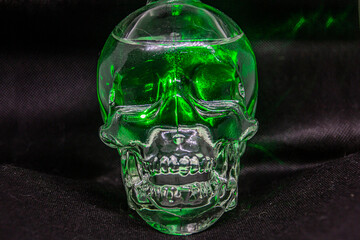 Glass skull illuminated by a green laser
