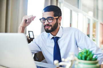 Wall Mural - Working from home means than I get more done. Shot of a young man using his laptop while working from home.